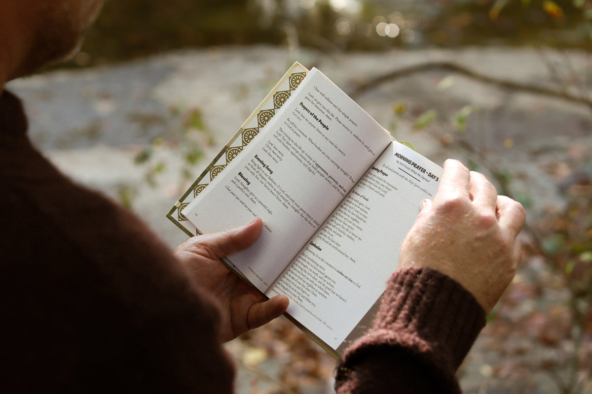 A reader holding The Quiet Hours open to Morning Prayer, Day 5